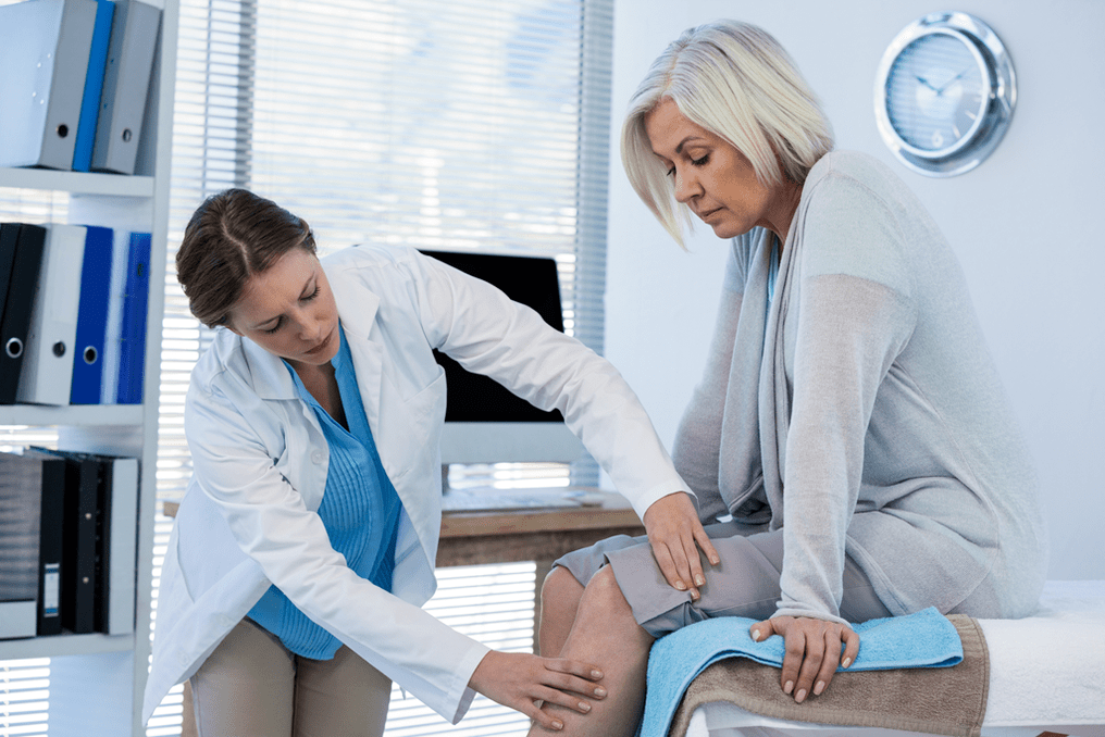 Un paciente con artrosis que necesita terapia siendo examinado por un médico.